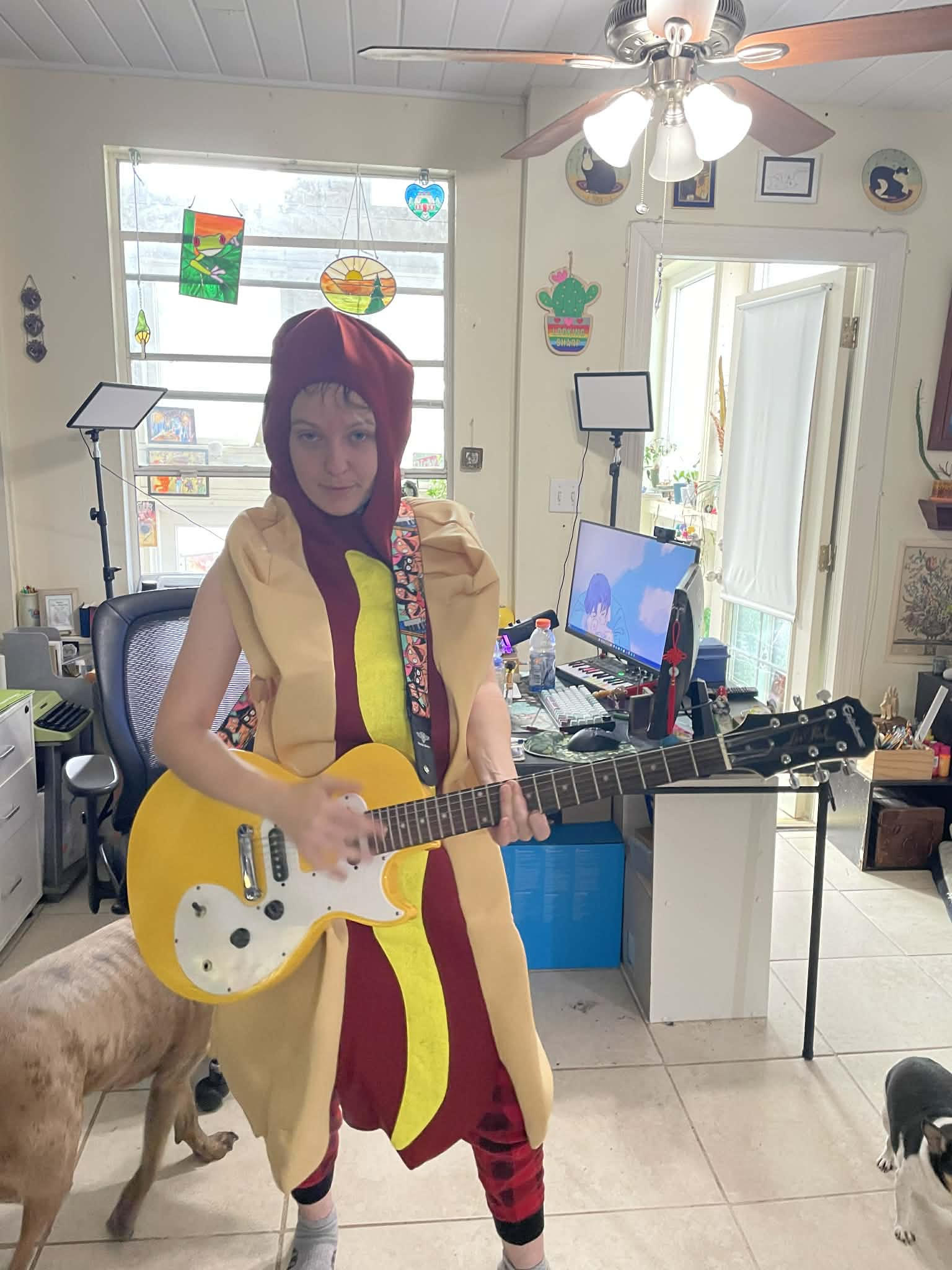 Nicole in a hot dog costume playing the guitar